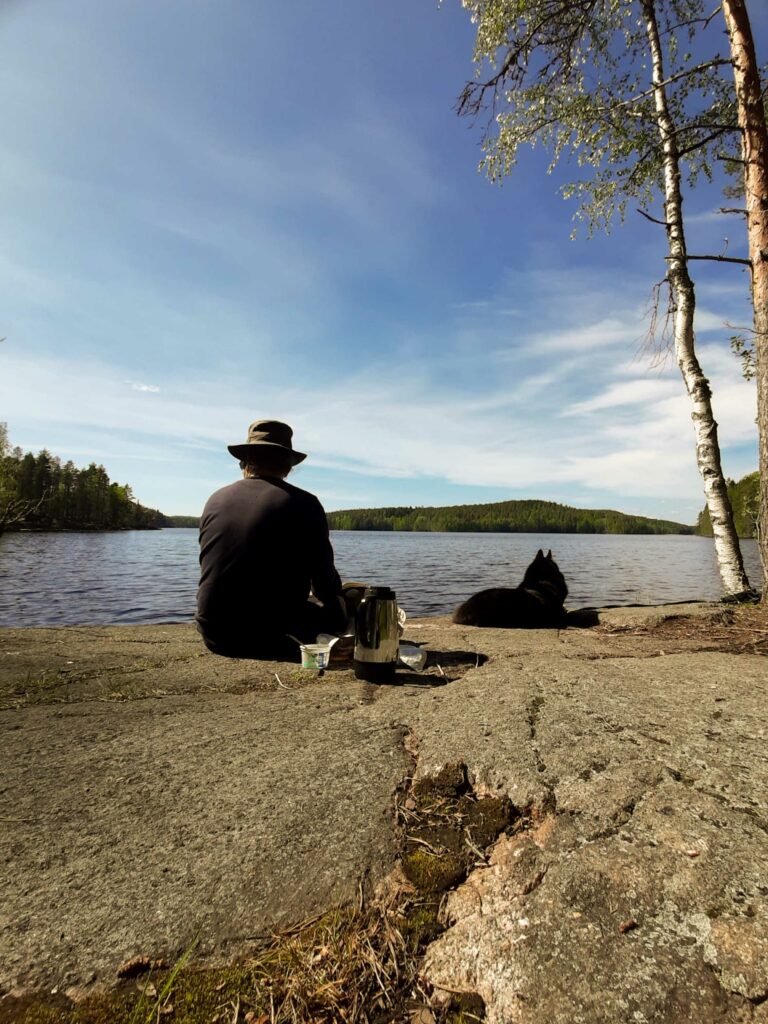 Väänänen istuu kalliolla selin kameraan. 